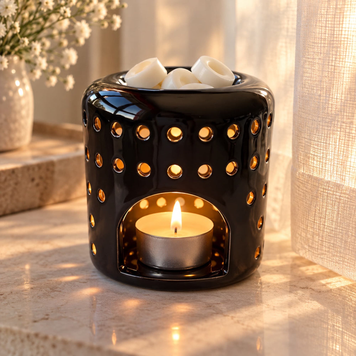 Quemador Vesta negro para wax melts con vela de té encendida