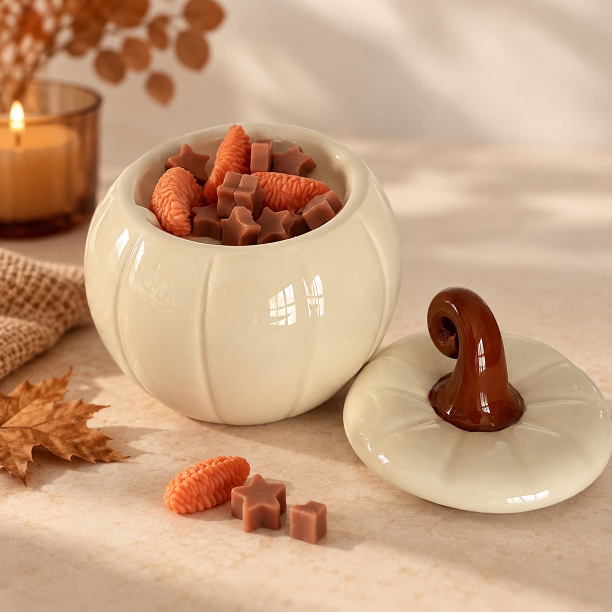 Quemador de cera con forma de calabaza crema abierto con wax melts en su interior