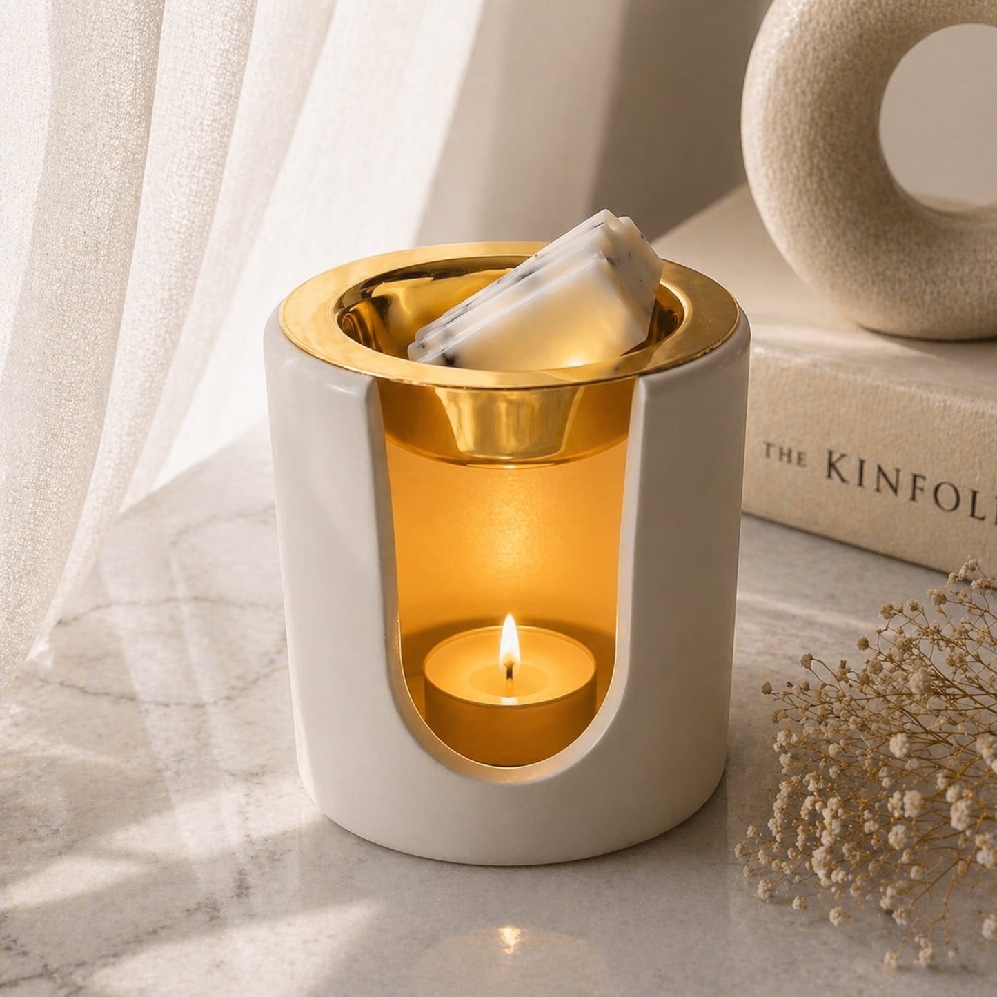 quemador wax melts Aura con platillo oro y vela de te encendida en ambiente decorativo Ayre