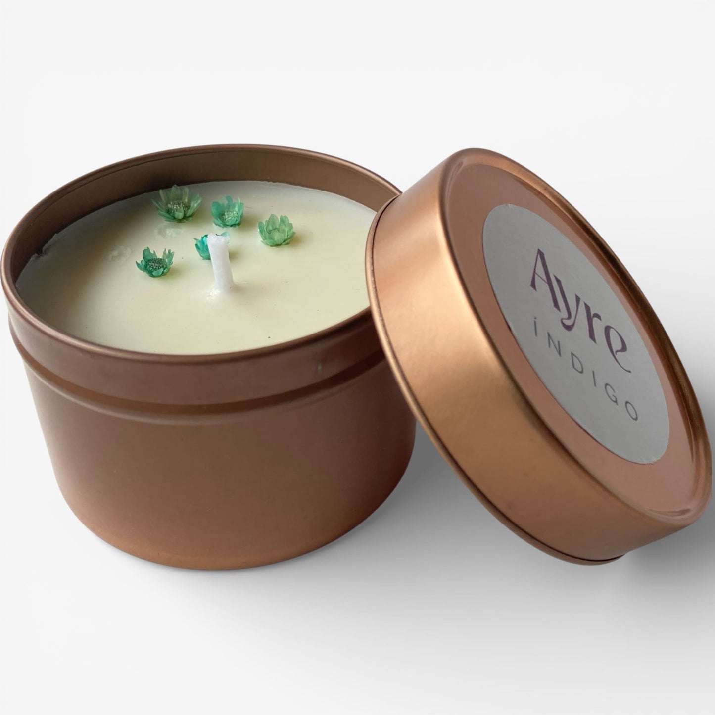 Vela aromática de soja Índigo Ayre abierta en lata metálica.