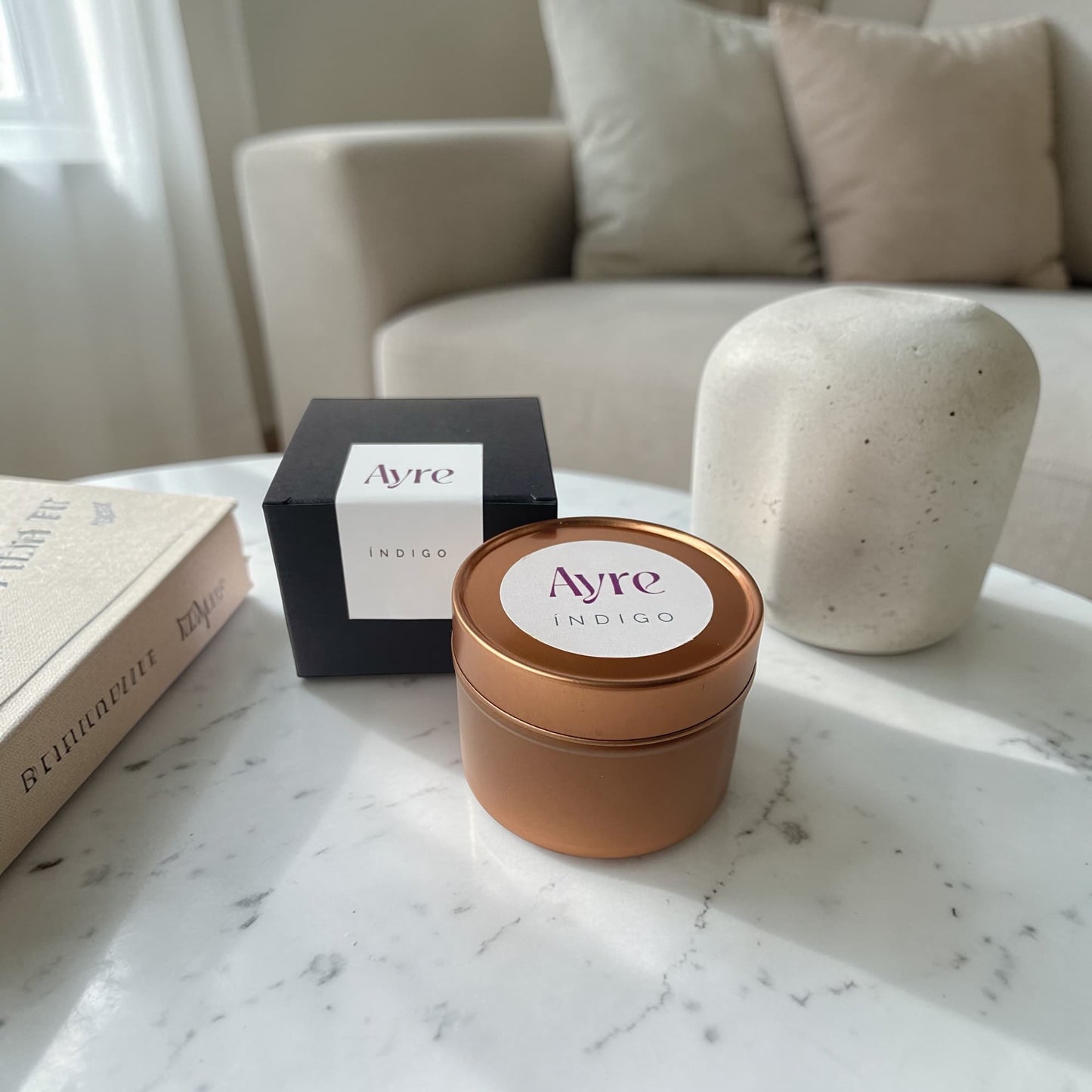 Vela aromática de soja Índigo Ayre en ambiente decorativo.