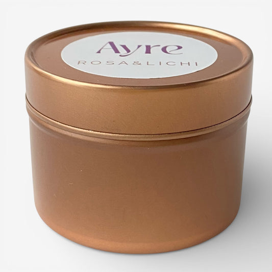 Vela aromática de soja Rosa y Lichi Ayre en lata metálica con fragancia floral y afrutada.