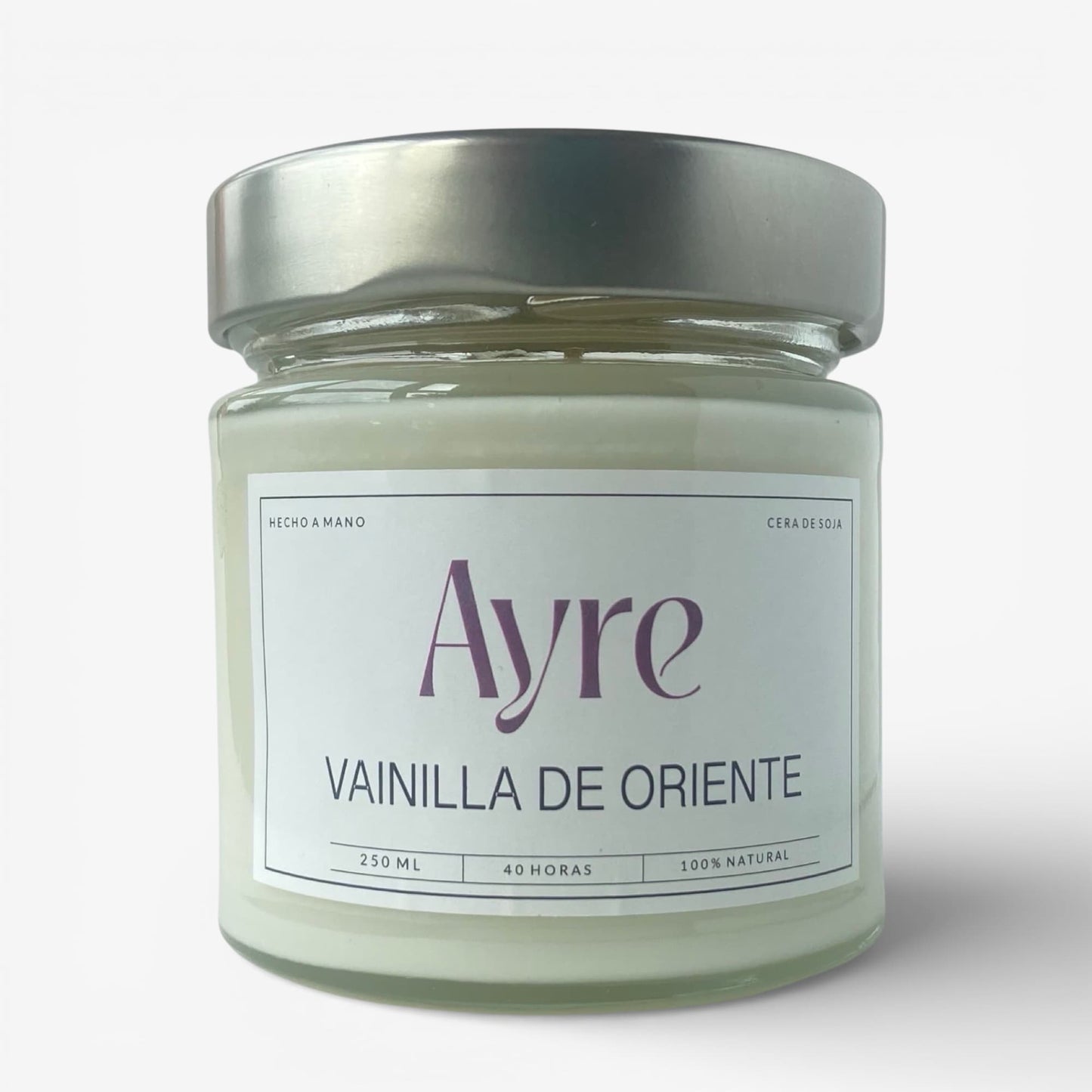 Vela aromática de soja Vainilla de Oriente Ayre en frasco de vidrio con tapa metálica y aroma dulce de vainilla.