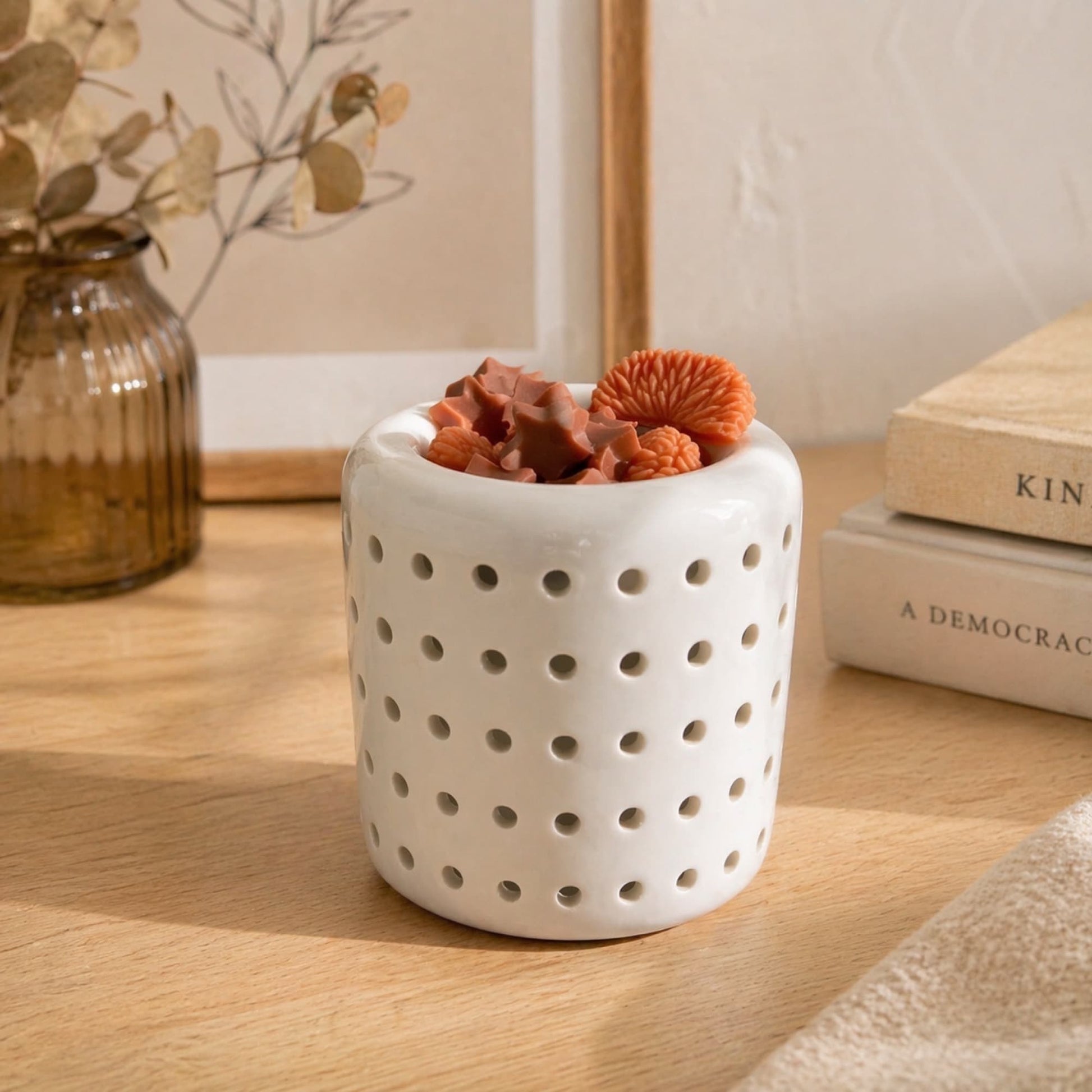 wax melts de soja aroma naranja y canela en quemador blanco en ambiente decorativo cálido